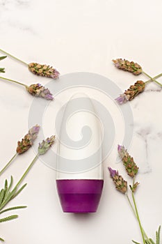 Blank plastic bottle with lavender flowers on a white and gray marble background