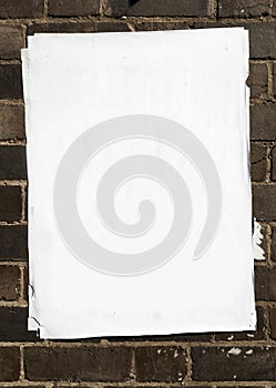 Blank poster atop of many other layers of paper pasted onto a br