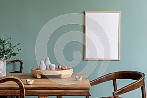 Blank poster frame and kitchen accessories in stylish dining room.