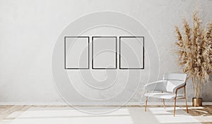 Blank poster frames in bright contemporary empty room interior with luxury white chair on wooden parquet floor and white
