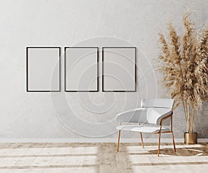 Blank poster frames in bright contemporary empty room interior with luxury white chair on wooden parquet floor and white