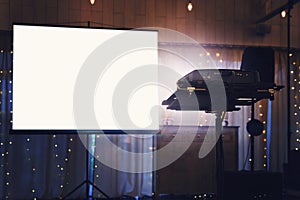 Blank projector screen mockup on the wall. Projection light in darkness. Projector display mock up. Presentation clear monitor on