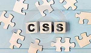 Blank puzzles and wooden cubes with the text CSS Cascading Style Sheets lie on a light blue background