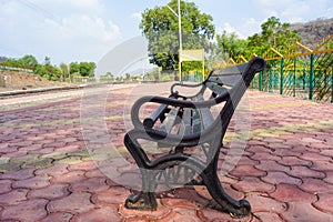 Blank railway sign board, seating bench at railway station platform of an Indian mountain village on a sunny summer day. Indian