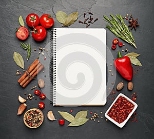 Blank recipe book and ingredients on black table, flat lay. Space for text