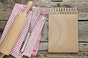 Blank recipe book and kitchen utensils on old wooden table, flat lay. Space for text