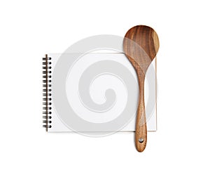 Blank recipe book and wooden spoon on white background, top view. Space for text