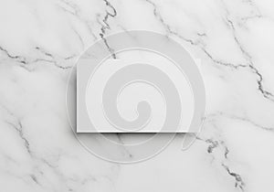 A blank rectangular white card centered on a smooth, elegant white marble surface with gray