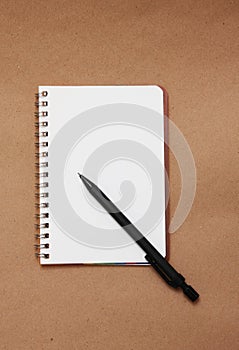 Blank reporters notebook and pencil on a brown pap photo