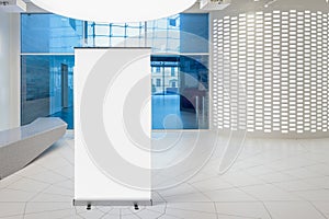 Blank roll up banner stand in contemorary office interior