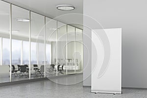 Blank roll up banner stand in modern office interior