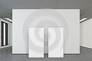 Blank roll up banner stands in gallery of white studio