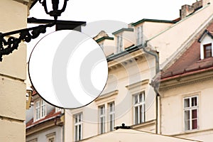 Blank round signboard, hanging from wrought iron bracket