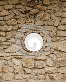 Blank round window on rock wall