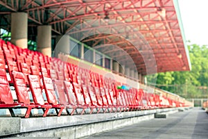 blank row of red plastic chairs on sport stadium