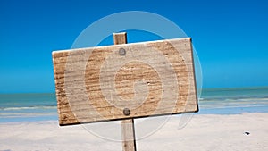 Blank rustic wooden sign on the beach