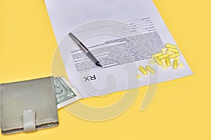 Blank rx prescription on pills. health money spending concept. yellow background