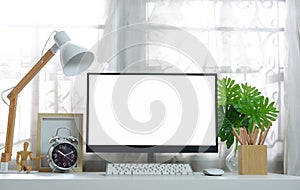 Blank screen on the desktop computer with house plant and office supplies, mockup