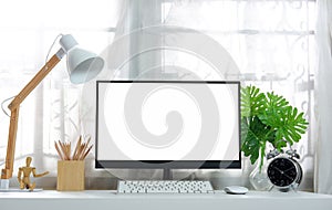 Blank screen on the desktop computer with house plant and office supplies, mockup