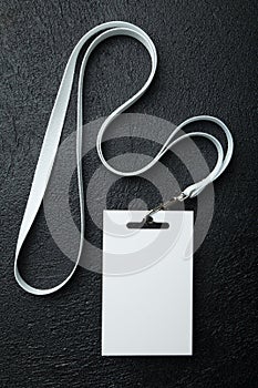 Blank security tag with white neck band isolated on black background, mockup