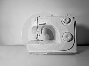 Blank sewing machine on a white table and a white wall background photo