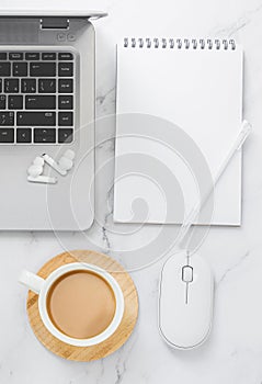 Blank sheet of paper notebook and cup on marble office desk.