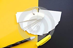 Blank sheets of Notepad are held together with a metal ring , mockup, pen and black yellow background .  Template with copy space
