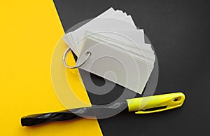 Blank sheets of Notepad are held together with a metal ring , mockup, pen and black yellow background .  Template with copy space