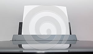 Blank sheets of paper coming out of an computer printer.