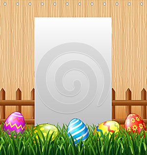 Blank sign in the grass field with decorated Easter eggs