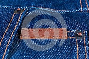 Blank small leather jeans label sewed on a blue jeans