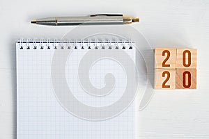 Blank spiral notebook, fountain pen, wooden cubes with numbers new year 2020