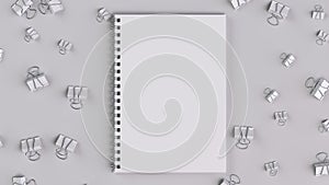 Blank spiral notebook with white binder clips on white table