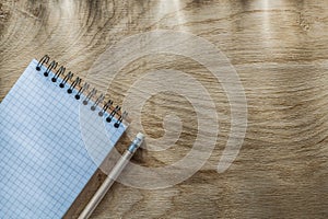 Blank spiral notepad pencil on wooden board top view