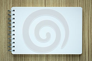 Blank spiral notepad on wood background