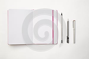 Blank spread, open book with pen and pensil