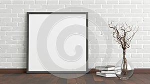 Blank square poster frame mock up standing on dark parquet floor next to white brick wall with vase and books. Clipping path aroun