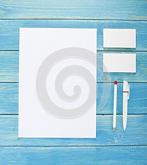 Blank Stationery on wooden background. Consist of Business cards, A4 letterheads, pen and pencil.