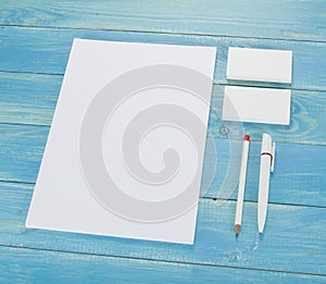 Blank Stationery on wooden background. Consist of Business cards, A4 letterheads, pen and pencil.