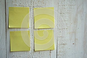 Blank sticky note pasted on a white wooden wall
