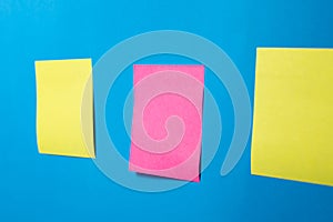 Three Blank Sticky Notes on Blue Wall at Angle