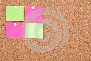 Blank sticky notes pinned on cork memo board