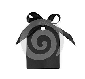 Blank tag with black satin ribbon tied in bow on white background, top view. Space for design