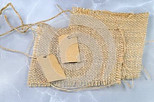 Blank tag tied with natural material string. Price tag, gift tag, sale tag, address label on Brown coarse.