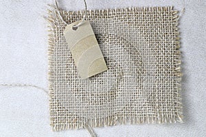 Blank tag tied with natural material string. Price tag, gift tag, sale tag, address label on Brown coarse.