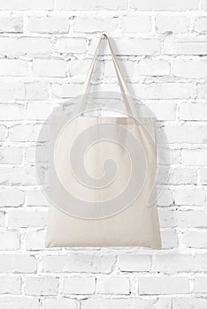 Blank Tote Canvas Bag Mockup on white brick wall background.