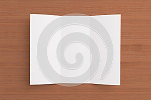 Blank tri fold brochure on wooden background photo