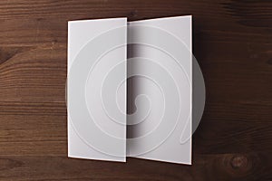 Blank tri fold brochure on wooden background to replace your design or message.