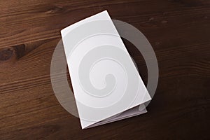 Blank tri fold brochure on wooden background to replace your design or message