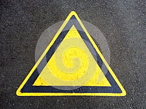 Blank triangle hazard, attention, warning, danger sign on the black asphalt